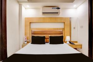 a bedroom with a white bed with a wooden headboard at Istay By A1Rooms in Jāmb +15 photos