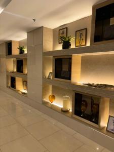 a lobby with a wall of shelves with candles at Shell Residences Tower A B in Manila