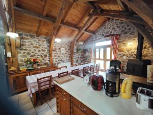 a kitchen with a counter and chairs in a building at La Butinerie in Prévenchères
