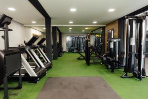 a gym with lots of tread machines and green carpet at Hotel Bergozza in Rio do Sul
