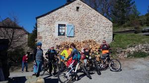 a group of people on bikes in front of a stone building at La Butinerie in Prévenchères +15 photos
