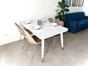 a white dining room table with chairs and a blue couch at Jungle - Sarnico Color Suites in Sarnico