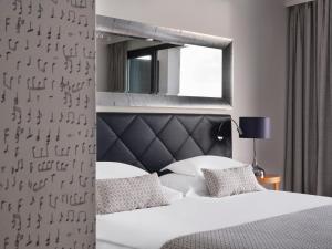a bedroom with a white bed and a mirror at Amadria Park Hotel Royal in Opatija +55 photos