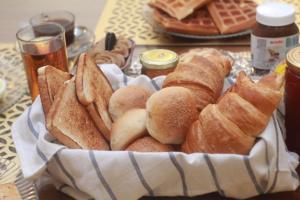a basket of bread and pastries on a table at World Inn by WIH in Karachi