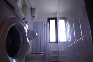 a bathroom with a toilet and a window at Mya Vacanze in Torre dell'Orso