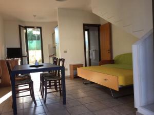 a room with a bed and a table and chairs at Mya Vacanze in Torre dell'Orso