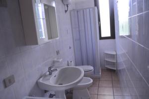 a white bathroom with a sink and a toilet at Mya Vacanze in Torre dell'Orso +17 photos