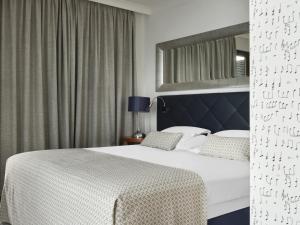 a hotel room with a bed and a window at Amadria Park Hotel Royal in Opatija