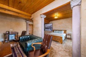 a bedroom with a bed and a couch in a room at Cratus Stone Palace in Göreme