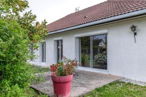 a house with a red potted plant in front of it at La Belle Escale - Maison proche gare et d'Orléans in Fleury-les-Aubrais