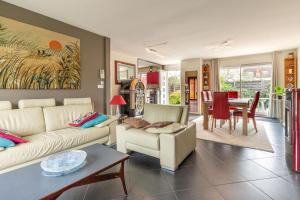 a living room with a couch and a table at La Belle Escale - Maison proche gare et d'Orléans in Fleury-les-Aubrais +4 photos