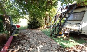 a yard with a ladder next to a house at Граничар 3 СЪРФА - морската каюта in Granichar