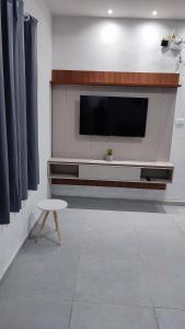 a living room with a flat screen tv on a wall at Águas de Maragogi residence in Maragogi