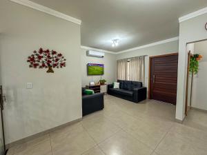 a living room with a couch and a tv at Casa Dos Papagaios in Bonito