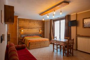 a bedroom with a bed and a table and a couch at Chalet Della Guida in Bardonecchia