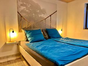 a bedroom with a bed with blue sheets and two lamps at Barrierefreies Ferienhaus mit Garten bei Köln in Hürth