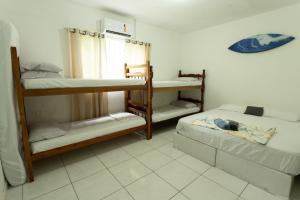 a room with three bunk beds and a window at Pousada da Sú in Bertioga +39 photos