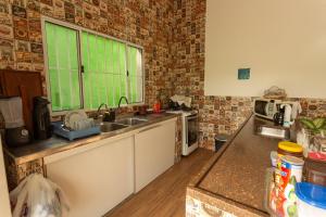 a kitchen with a sink and a window at Pousada da Sú in Bertioga