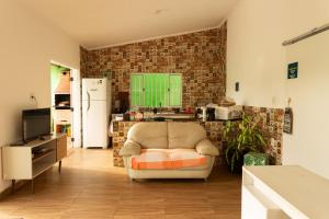 a living room with a couch and a brick wall at Pousada da Sú in Bertioga