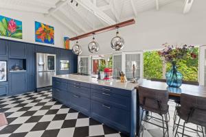 a kitchen with blue cabinets and a checkered floor at Sunset House in Willibrordus