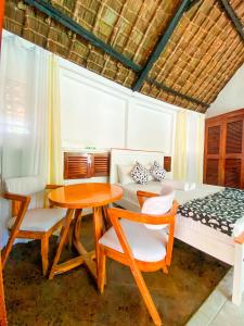 a bedroom with a bed and a table and chairs at Palm Villa at Villa Sol in Mombasa