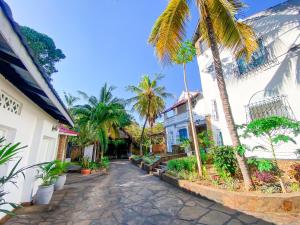 a street with palm trees and a building at Palm Villa at Villa Sol in Mombasa