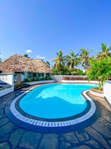 a swimming pool in front of a resort at Palm Villa at Villa Sol in Mombasa