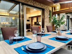 a dining table with blue napkins and glasses on it at Barrierefreies Ferienhaus mit Garten bei Köln in Hürth