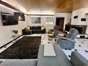 a living room with a couch and chairs and a tv at Barrierefreies Ferienhaus mit Garten bei Köln in Hürth