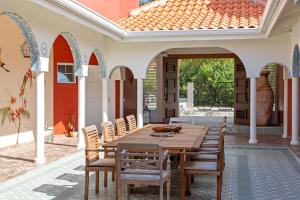an outdoor patio with a wooden table and chairs at Sunset House in Willibrordus