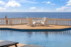 two chairs and a table next to a swimming pool at Sunset House in Willibrordus +31 photos