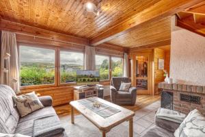 a living room with a couch and a table and a tv at Seepark-Lodge in Kirchheim