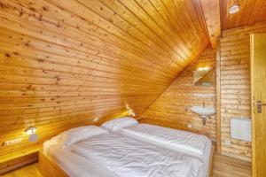 a bedroom with a bed in a wooden room at Seepark-Lodge in Kirchheim
