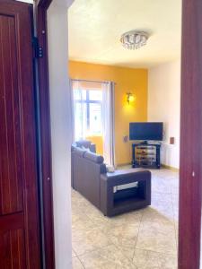a living room with a couch and a television at Appartement first floor in Trou aux Biches