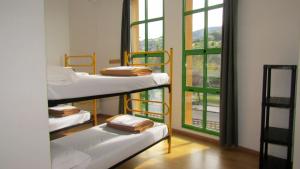 a room with three bunk beds and a window at Albergue El Floran in Blimea
