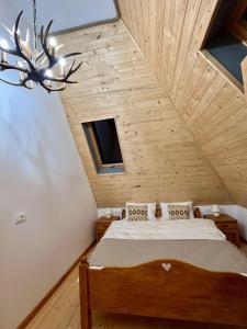 a bedroom with a bed and a ceiling with a chandelier at Chalet De Paul in Moisei