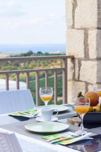 a table with two glasses of wine and a bowl of fruit at Villa Afroditi in Agia Triada