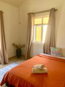 a bedroom with an orange bed with a window at Appartement first floor in Trou aux Biches