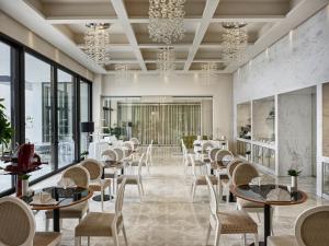 a restaurant with tables and chairs and windows at Amadria Park Hotel Royal in Opatija