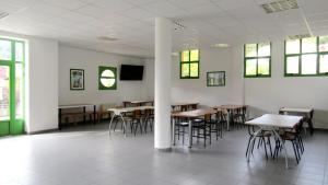 a dining room with tables and chairs and windows at Albergue El Floran in Blimea +26 photos
