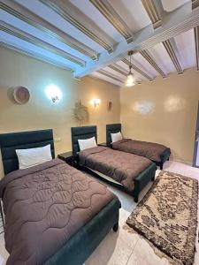 ein Schlafzimmer mit zwei Betten in einem Zimmer in der Unterkunft Hôtel Zaghro in Ouarzazate