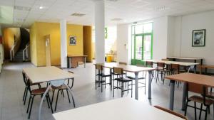a classroom with tables and chairs in a building at Albergue El Floran in Blimea