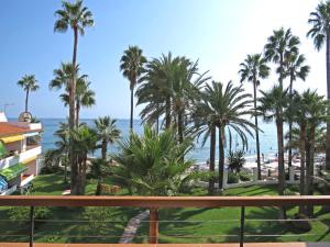 a beach with palm trees and palm trees at Apartamentos Playa Torrecilla in Nerja