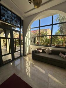 ein Wohnzimmer mit Sofa und großem Fenster in der Unterkunft Hôtel Zaghro in Ouarzazate