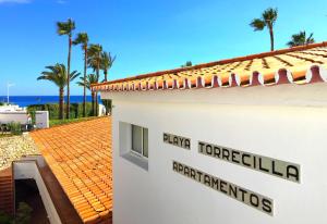 un edificio con el cartel para dana torrevieja seminarios de expertos en Apartamentos Playa Torrecilla, en Nerja