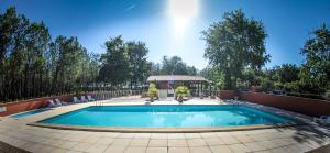 a swimming pool with chairs and a gazebo at Camping le Laha in Lesperon