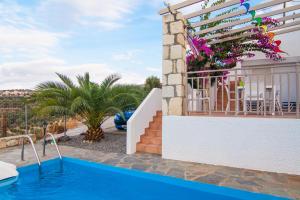 a villa with a swimming pool and a patio at Villa Afroditi in Agia Triada