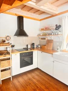 a kitchen with white cabinets and a stove at Roubenka in Terchová