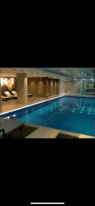 a large blue swimming pool in a building at Оrbi Palase Deluxe in Bakuriani