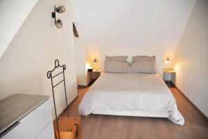 a bedroom with a bed with white sheets and wooden floors at Au logis de Bayard in Vareilles +16 photos